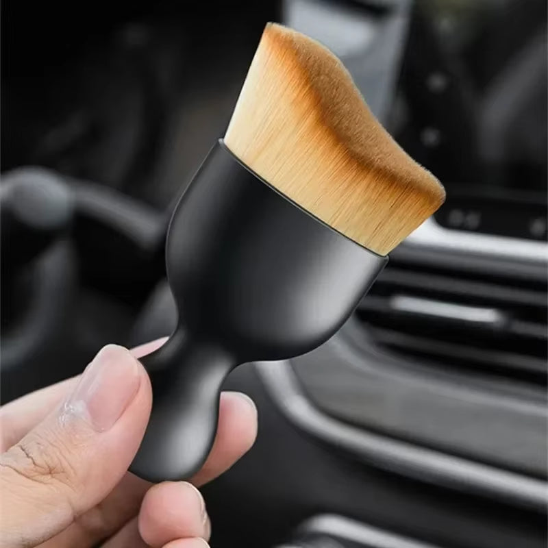 Cleaning dust from a car air vent with the soft brush